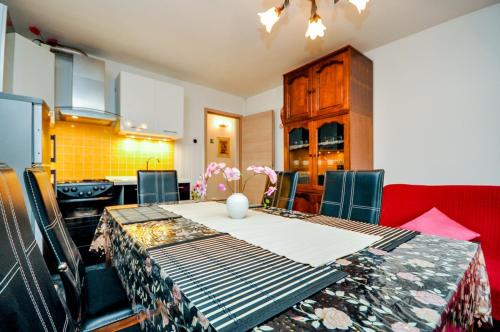 uma cozinha com uma mesa de jantar e uma cozinha com uma cozinha em Apartments Crvena Orhideja em Split