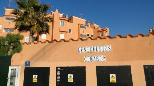 un edificio con un cartel en el costado en HE Lux Las Calitas, en Orihuela Costa