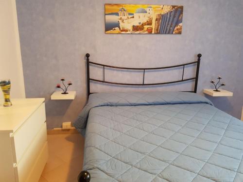 um quarto com uma cama e um quadro na parede em Casa Loredana em Scauri