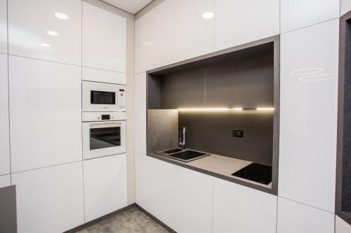 a kitchen with white cabinets and appliances at North Avenue Modern Apartments in Yerevan