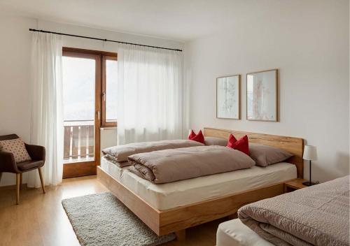 1 Schlafzimmer mit 2 Betten und roten Kissen in der Unterkunft Appartement Karnutsch in Schenna