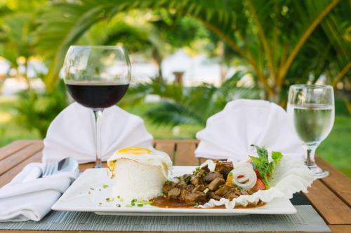 a plate of food and a glass of wine on a table at Long Set Resort in Koh Rong Island