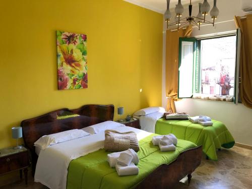 a bedroom with two beds with green sheets at Etna Vintage in Linguaglossa