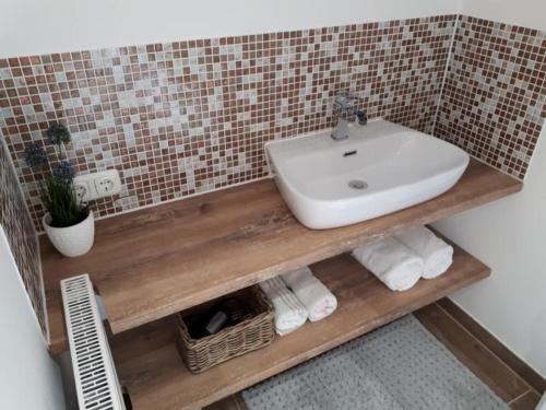 a bathroom with a sink and a shelf with towels at Haus Kuchler in Bayerisch Eisenstein