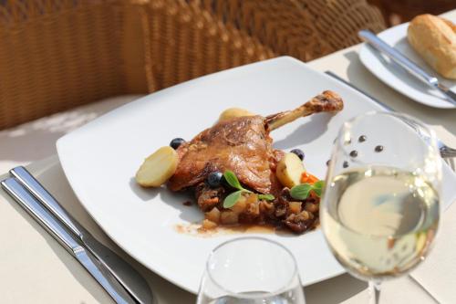 a plate of food on a table with a glass of wine at Mon Port Hotel & Spa in Port d’Andratx