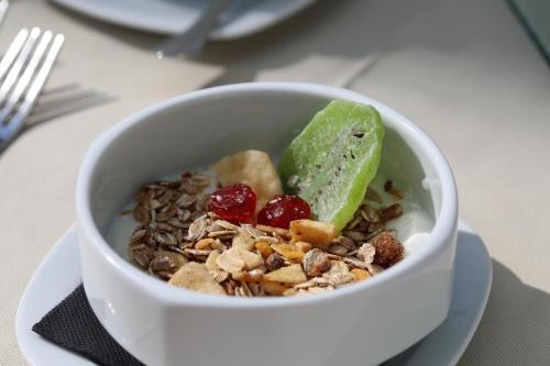 a bowl of granola on a plate with a fork at Mon Port Hotel & Spa in Port d’Andratx