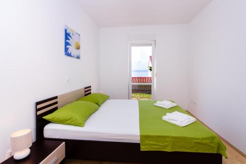 ein Schlafzimmer mit einem großen Bett mit grünen Kissen in der Unterkunft Apartment Jusepe in Trogir