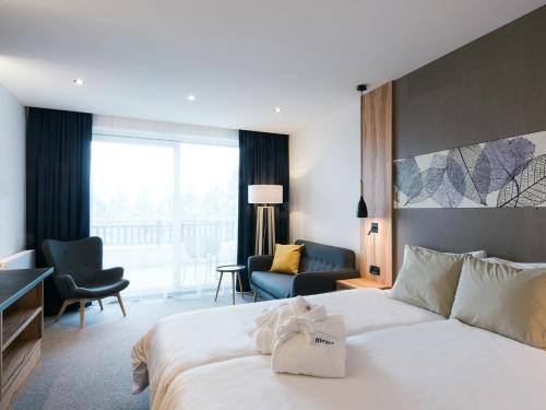 une chambre d'hôtel avec un lit et un salon dans l'établissement Hotel Ifinger, à Schenna