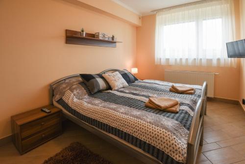 una camera da letto con un letto e due asciugamani di Rózsa Völgy Apartman a Eger