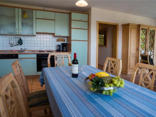 a table with a bottle of wine and a bowl of fruit at Am Maiglöckchenberg 19 in Ostseebad Karlshagen