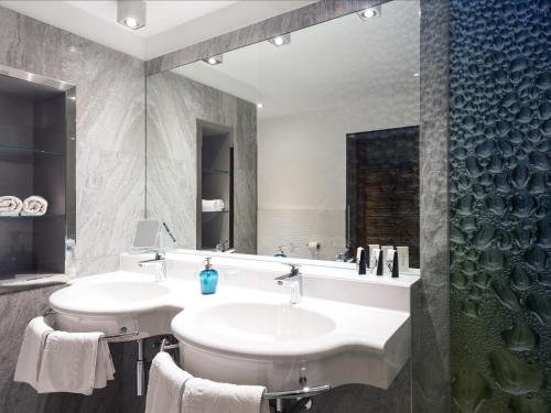 een badkamer met 2 wastafels en een douche bij Hotel Ifinger in Schenna