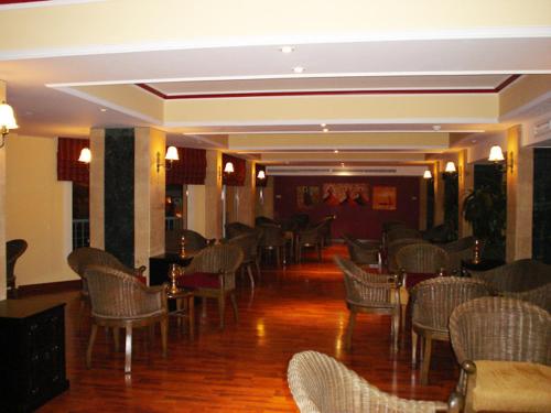 a room filled with chairs and tables and a room with wood floors at Sea Garden Hotel in Hurghada