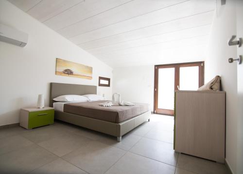マリーナ・ディ・ラグーザにあるVille Edilia Vacanzeの白いベッドルーム(ベッド1台、窓付)