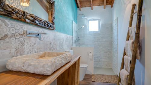 a bathroom with a stone sink and a shower at Casa Baliza, adults only in Alhaurín el Grande