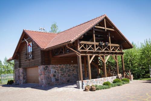 a large wooden house with a garage at Apartamenty Osowa nad jeziorem Okmin in Suwałki