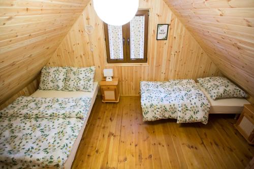 - une chambre avec 2 lits dans une cabane en bois dans l'établissement Domki Letniskowe Roztocze, à Zwierzyniec