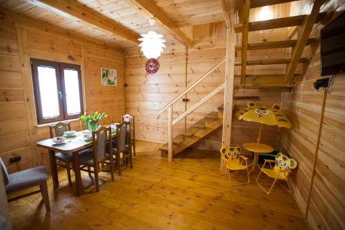 une salle à manger avec une table et un escalier dans l'établissement Domki Letniskowe Roztocze, à Zwierzyniec