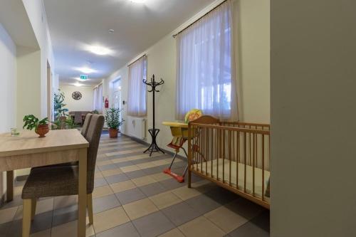 - une chambre avec un lit bébé et une table dans l'établissement Tölgyfa Vendégház, à Kiskőrös