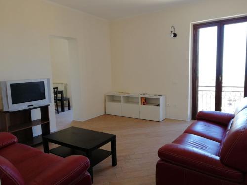 uma sala de estar com um sofá e uma televisão em Backpackers em Agrigento