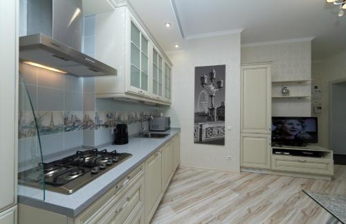 a kitchen with white cabinets and a stove top oven at Апартаменты на Бассейной in Kyiv