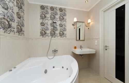 a white bathroom with a tub and a sink at Апартаменты на Бассейной in Kyiv