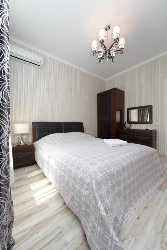 a bedroom with a large bed and a chandelier at Апартаменты на Бассейной in Kyiv