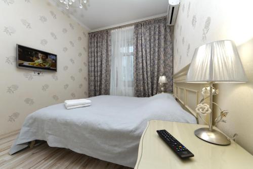 a bedroom with a bed and a desk with a lamp at Апартаменты на Бассейной in Kyiv