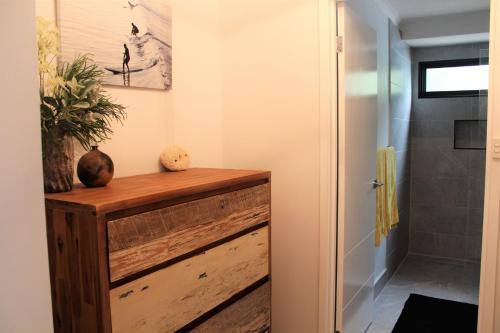 ein Flur mit einer Holzkommode in einem Badezimmer in der Unterkunft Mignon Cottage 9 Noongah Terrace in Crescent Head