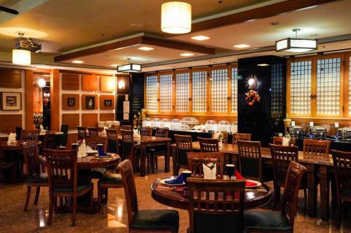Un comedor con mesas y sillas en un restaurante. en Hotel Good Morning, en Ulsan