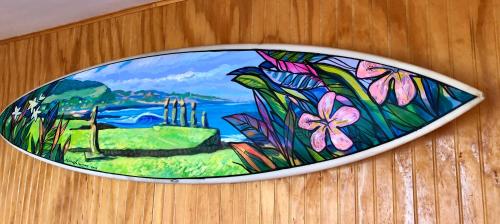 a plate with a painting of flowers on a table at Cabañas Anavai Rapa Nui in Hanga Roa