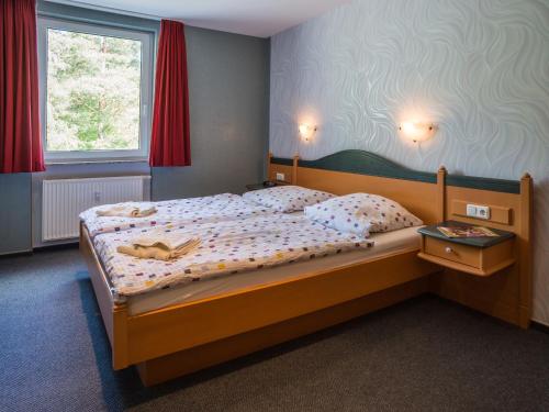 een slaapkamer met een houten bed in een kamer bij Ferienhaus am Maiglöchchenberg 5 in Ostseebad Karlshagen