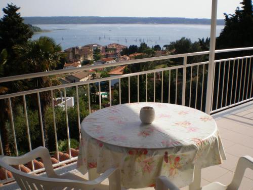 a table and chairs on a balcony with a view of the water at Apartments Heidi in Portorož
