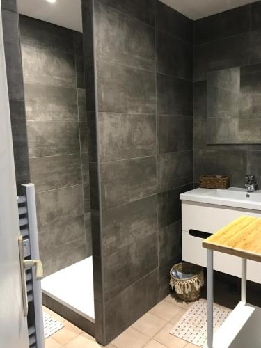 a bathroom with a gray tiled wall at Le Domaine Vermeil in Argelès-sur-Mer
