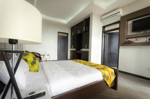 a bedroom with a white bed and a lamp at The Venti Hotel & Spa in Kampala
