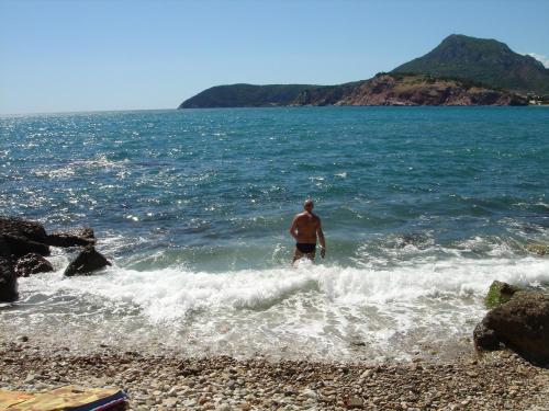 a man standing in the water at the beach at BG apartman in Sutomore