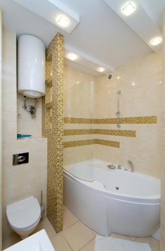 a bathroom with a white tub and a toilet at Апартаменты на Бассейной in Kyiv