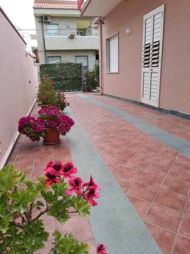 a patio with flowers and plants on a building at B&B President Palace in Riposto