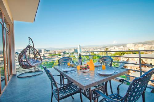 einen Tisch und Stühle auf einem Balkon mit Aussicht in der Unterkunft Hotel Orion Tbilisi in Tbilisi City