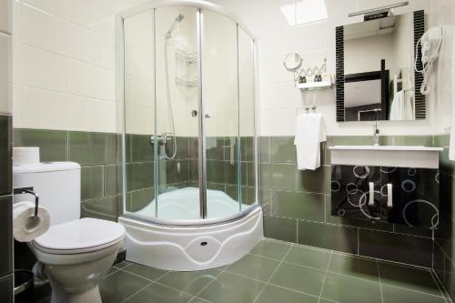 a bathroom with a shower and a toilet and a sink at Hotel Orion Tbilisi in Tbilisi City