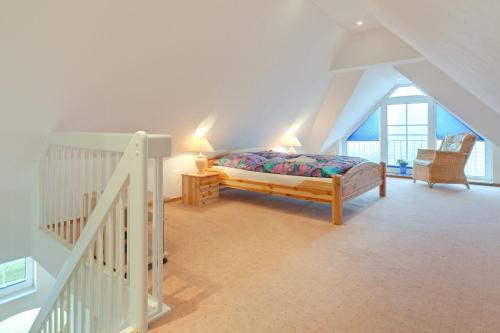 ein Schlafzimmer mit einem Bett im Dachgeschoss in der Unterkunft Appartement "Ostsee" in Zingst