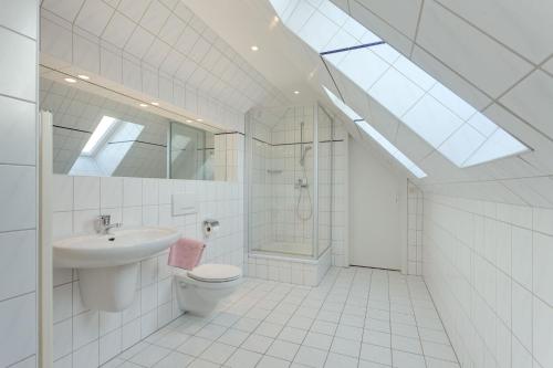 La salle de bains est pourvue de toilettes, d'un lavabo et d'une douche. dans l'établissement Appartement "Ostsee", à Zingst
