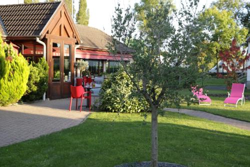 a tree in the grass in front of a building at ibis Strasbourg Sud La Vigie in Ostwald