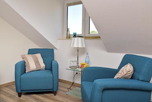 two blue chairs and a table in a room at Weindepot Xanten in Xanten