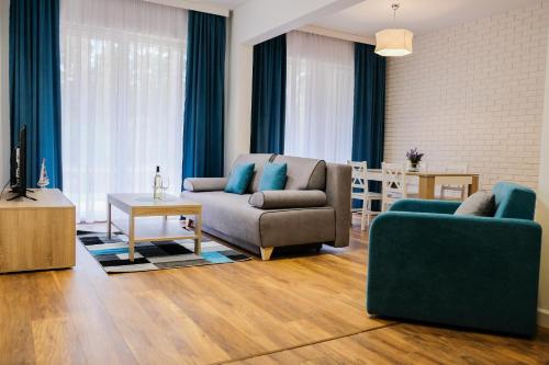 a living room with two chairs and a couch at Apartment & Room MARINA BORKI - Apartamenty ZEFIR in Augustów