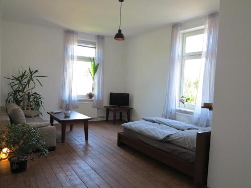 a bedroom with a bed and a couch and two windows at Ferienwohnung Krempe in Krempe
