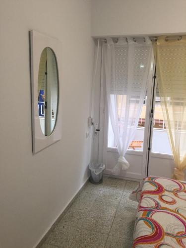 ein Schlafzimmer mit einem Spiegel, einem Bett und einem Fenster in der Unterkunft Gran Notch in Alicante