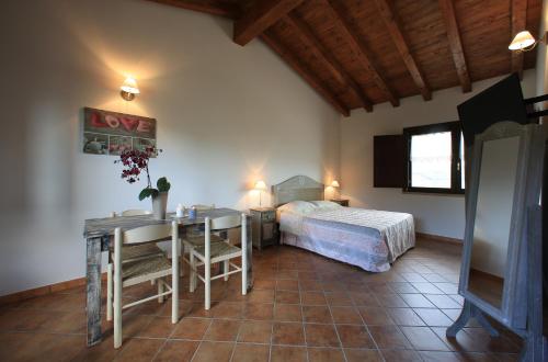 a bedroom with a bed and a desk and a table at Casale Madeccia in Sonnino