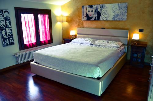 a bedroom with a large bed and two windows at Villa Anis Bed and Breakfast in Selvazzano Dentro