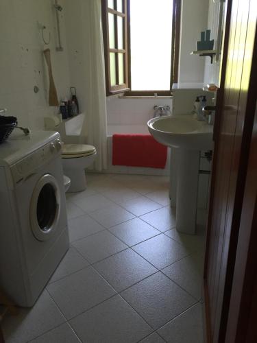 ein Badezimmer mit einer Waschmaschine und einem Waschbecken in der Unterkunft Chia - Casa Margherita in Chia