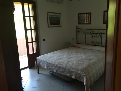 ein Schlafzimmer mit einem Bett in der Ecke des Zimmers in der Unterkunft Chia - Casa Margherita in Chia